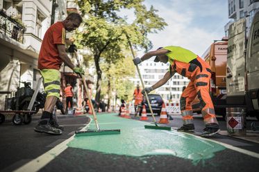 Beschichtungsarbeiten mit grüner Farbe auf einem Radweg in Berlin