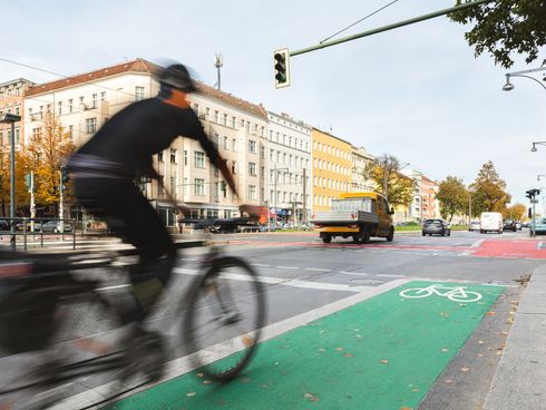 Radfahrer auf einem grün markierten Radfahrstreifen vor einer Kreuzung