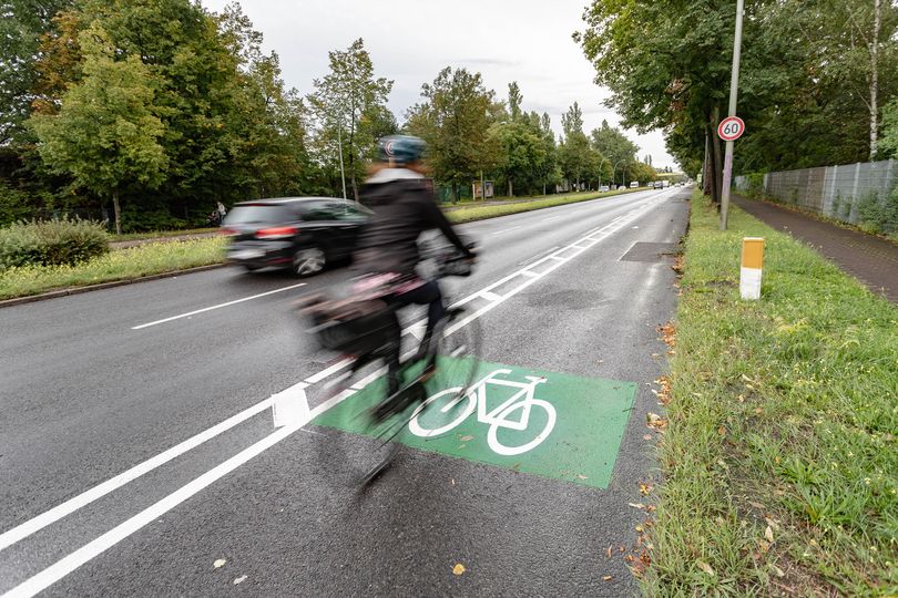 Eine Radfahrerin nutzt am Adlergestell einen Radfahrstreifen mit Schutzstreifen.